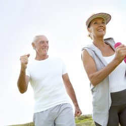 A happy elderly couple doing some exercise outdoors together